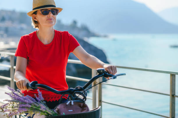 Mature woman riding a bicycle by the sea