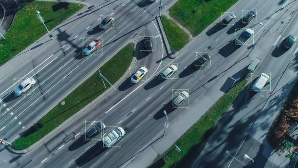 istock Aerial Drone Shot: Autonomous Self Driving Cars Moving On City Freeway. Concept: Artificial Intelligence Scans Cars and Pedestrians, Following Movement and Showing Data. 1329665091