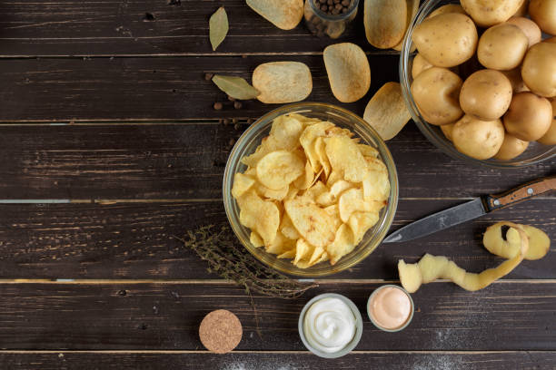 knusprige chips und rohe kartoffeln - potato chip stock-fotos und bilder