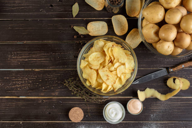 patatas fritas crujientes y patata cruda - potatoe chips fotografías e imágenes de stock