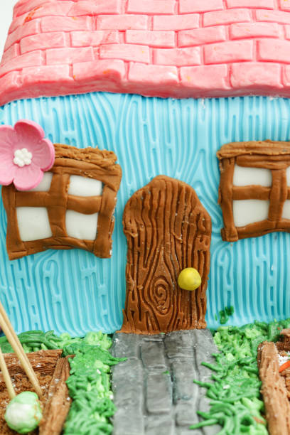 istock Full frame image homemade cake designed as cottage and garden with raised vegetable beds, butter icing grass with chocolate flake and biscuit crumb soil vegetable plots, fondant icing pumpkins and pathway 1329667828