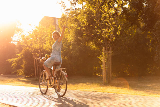 Girl on a bike ride in a spring park. Stands with a bike.
