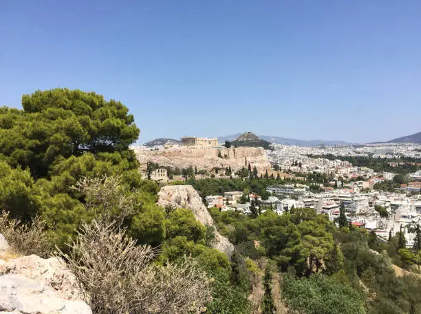 Photo of View of the Parthenon on the Athenian Acropolis and Mount Lycabettus, seen from Filopappou Hill in Athens, Greece.