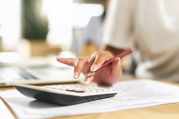 Shot of a businesswoman using a calculator to budget her finances Calculating my future finances accountancy stock pictures, royalty-free photos & images