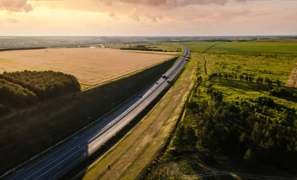 istock Highway going through agricultural fields at sunset. Aerial view 1329676053