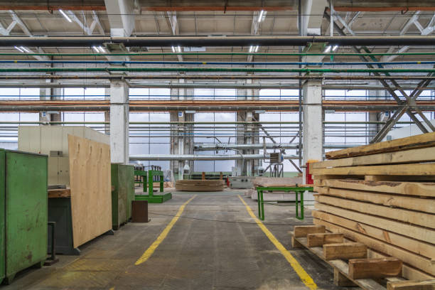 istock Typical woodworking factory interior, large workshop with automated machines and stacks of timber 1329677296