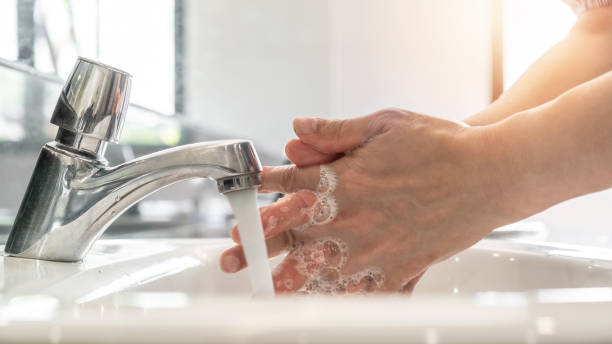 lavado de manos frotando con jabón líquido antibacteriano para desinfección, protección contra covid-19, prevención del coronavirus e higiene para detener la propagación del coronavirus mediante el uso de agua del grifo y desinfectante en el fregader - scrubbing up fotografías e imágenes de stock