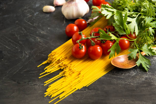 istock dry spaghetti, tomato on a concrete background 1329678027