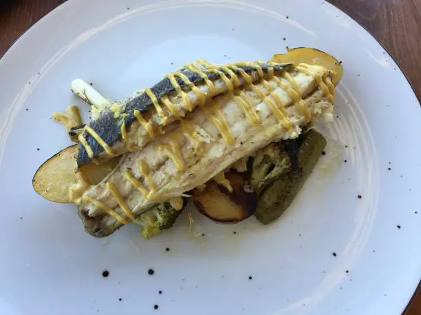 Photo of Sautéed sea bass fillet, vegetable ratatouille, pickled gherkins and mustard-lemon sauce served in Athens, Greece