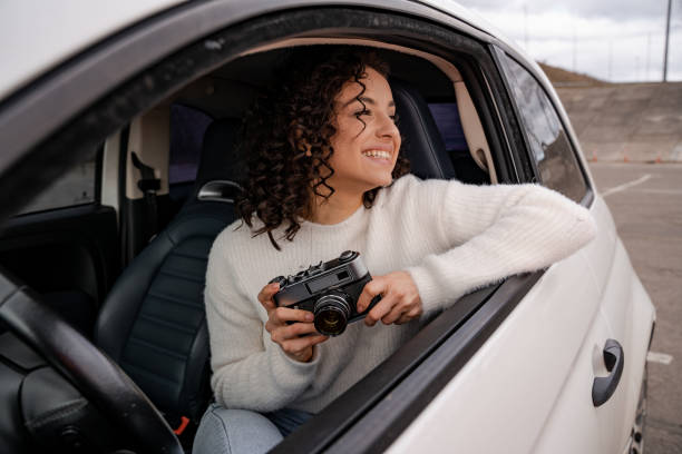 istock Girl sitting in automobile with old camera 1329682868