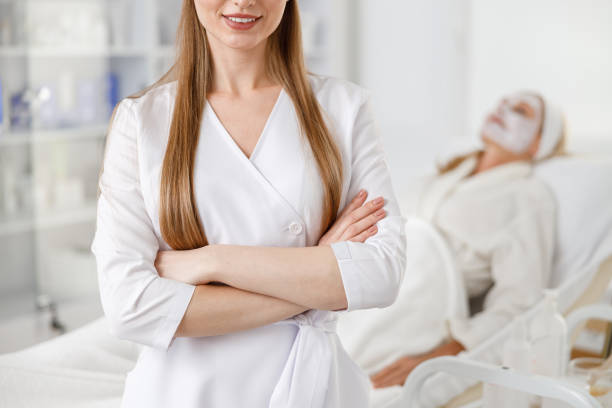 istock Close up dermatologist with hands crossed standing by a patient lying on the couch while medical procedure. 1329682971