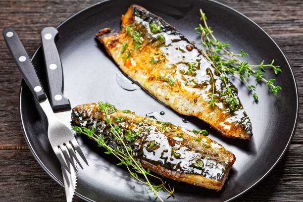 istock orange glazed fried mackerel fillets with spices and thyme on a black plate 1329683273