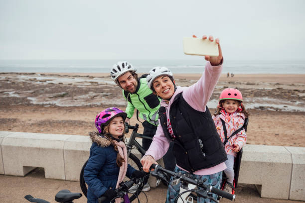 Making Memories Mixed race family taking a selfie while on a bike ride near the coast in the North east of England. cycling helmet photos stock pictures, royalty-free photos & images