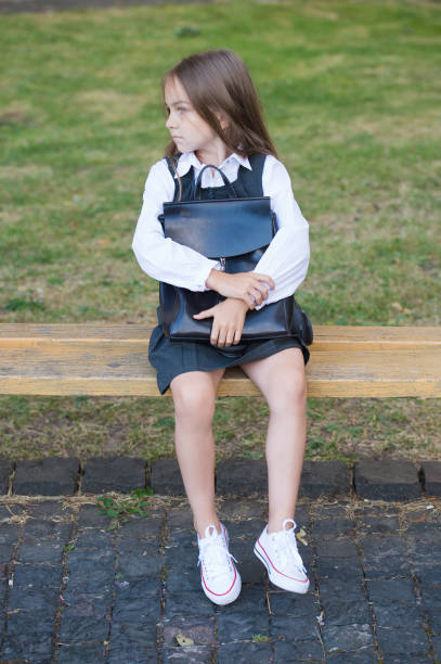 istock Early learning. Little child sit on bench outdoors. Childhood education. Nursery school. Childhood care. Childcare. Daycare preschool. Private and public teaching. International childrens day 1329684845