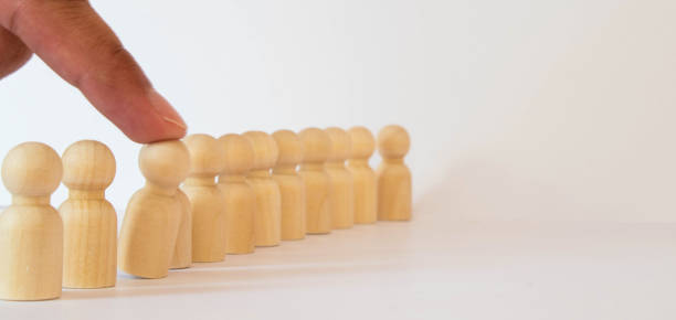 istock Small group of separated people seen from above represented anonymous with wooden figures on white background. 1329685574