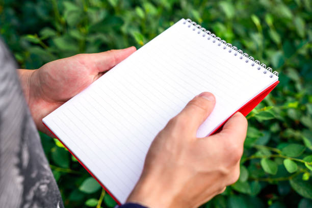 istock A man holds a book notebook in a green summer park 1329686252