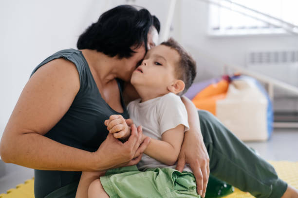 istock Mother playing with cute disabled child, cerebral palsy 1329687005