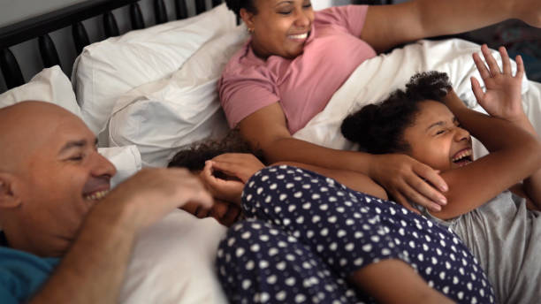 istock Family playing in bed tickling daughters 1329687074