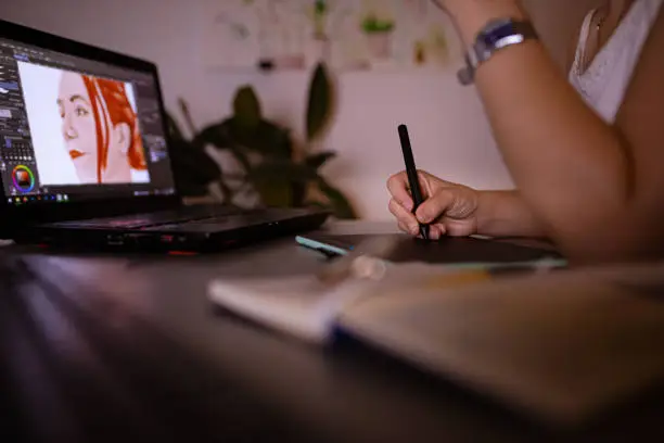 Photo of Curious female digital art student, learning new illustration techniques, late at night from her home office