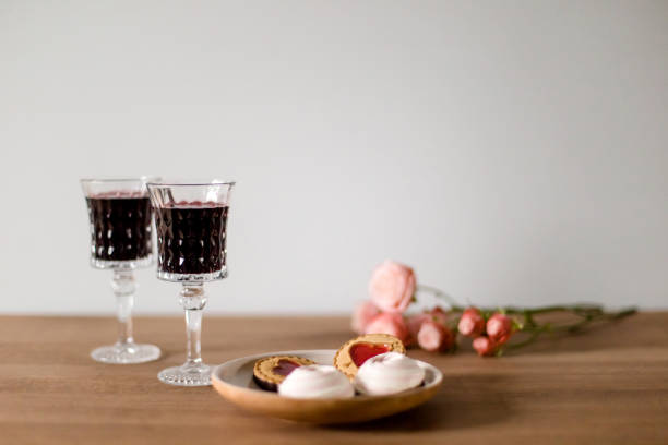 istock Roses, glasses with cherry liqueur and sweets on a table 1329688437