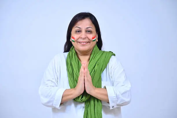 Photo of Indian senior woman in white salwar kameez standing in a greeting  pose on the occasion of Independence day