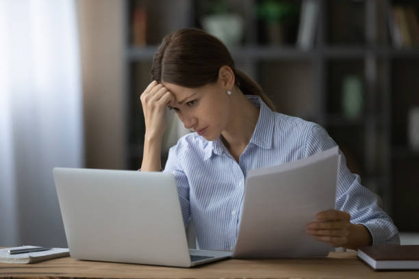 gestresste junge geschäftsfrau, die fehler im finanzbericht findet. - unemployment fear depression women stock-fotos und bilder