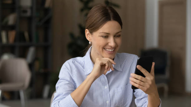 istock Happy young woman using smartphone applications in office. 1329690267