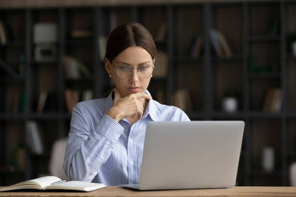 istock Thoughtful young businesswoman in eyewear working on computer. 1329690583