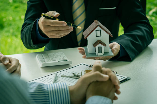 The dealer offers a home purchase contract or discusses a loan and interest rates. Between new homeowners when signing up to buy a home or rent on a desk, workspace, home buying and renting ideas. el concesionario ofrece un contrato de compra de vivienda o discute un préstamo y las tasas de interés. entre los nuevos propietarios al inscribirse para comprar una casa o alquilar en un escritorio, espacio de trabajo, compra de vivienda e ideas de alqu