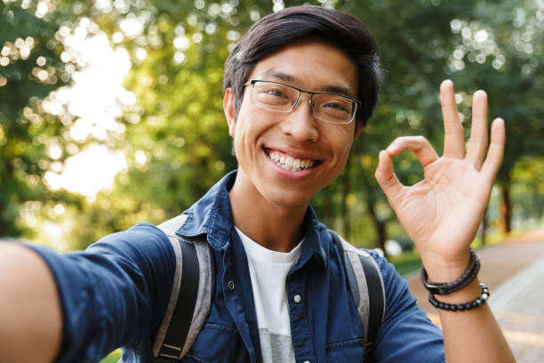 istock Smiling asian male student in eyeglasses making selfie 1329691589