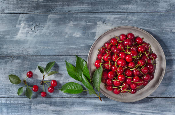 istock Cherries in plate on wooden background 1329694627