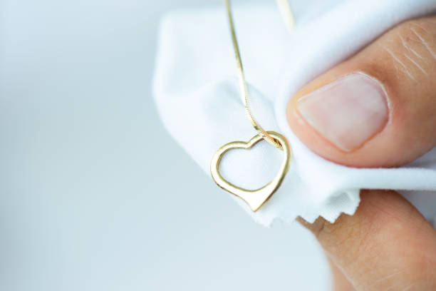 Jeweler is polishing necklace.