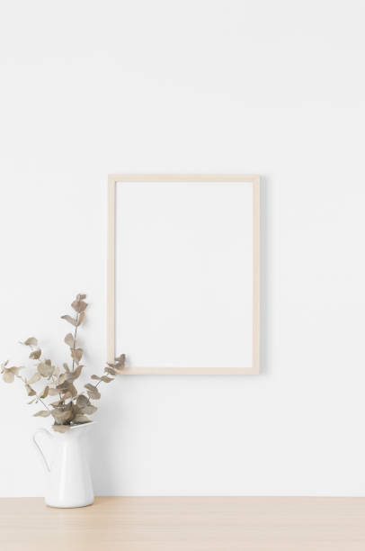 istock Wooden frame mockup on the wall with a eucalyptus. 1329698180