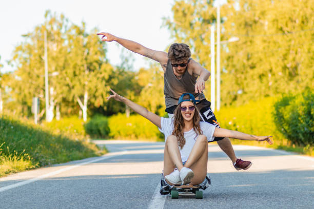 istock Young couple riding skateboards on the road 1329698520