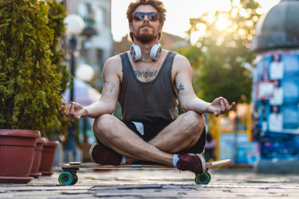istock Young Man doing yoga, relaxing on skateboard. 1329698547
