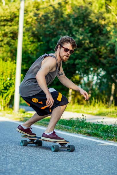 istock Riding skateboard. Riding longboard downhill on a beautiful sunset 1329698554
