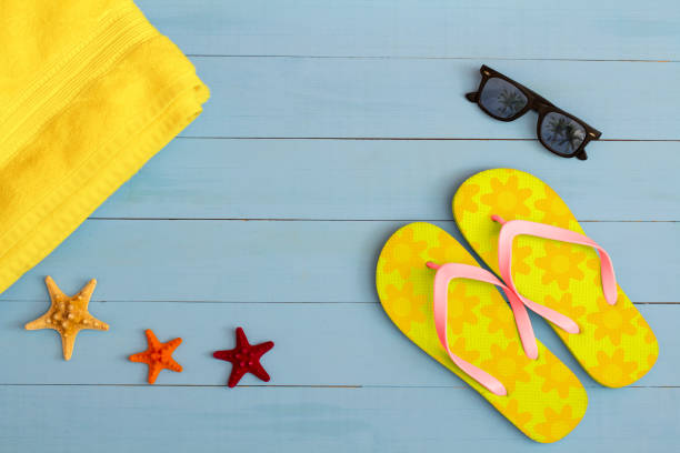 istock Summer time on a cool view on painted light blue wood table with sunglasses, flip flops, towel and starfish 1329700796