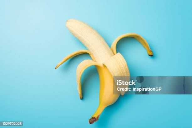 Top View Photo Of One Peeled Ripe Banana In The Middle On Isolated Pastel Blue Background Stock Photo - Download Image Now