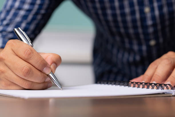 istock Businessman signing document after reading the agreement in office, hand writing. 1329702601