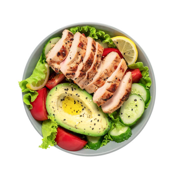 Grilled chicken with fresh vegetable salad with seeds in a bowl isolated on white background. View from above. Healthy food and keto diet concept. Grilled chicken with fresh vegetable salad with seeds in a bowl isolated on white background. View from above. Healthy food and keto diet concept ketogenic diet stock pictures, royalty-free photos & images