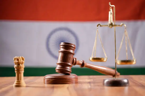 Photo of Concept of Indian justice system showing by using Judge Gavel, Balance scale on Indian flag as background