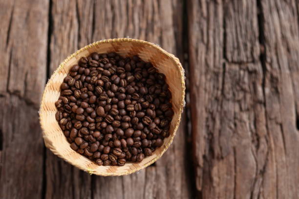 istock Coffee Beans Peaberry small size picking in bamboo basket. log wooden background. Selective focus on foreground with copy space. 1329707667