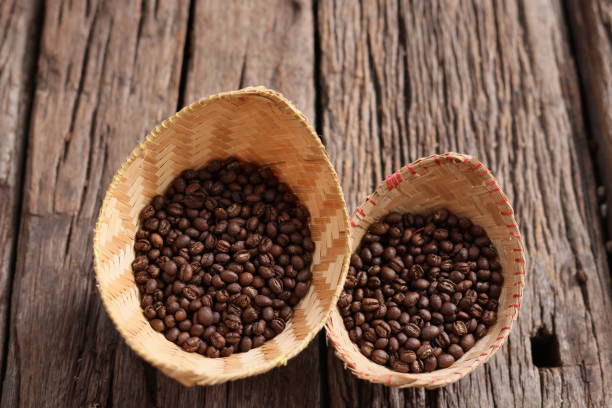 istock Coffee Beans Peaberry small size picking in bamboo basket. log wooden background. Selective focus on foreground with copy space. 1329707677