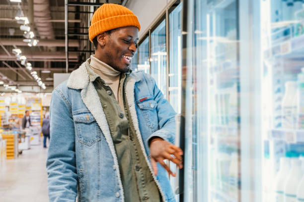 istock African-American guy with green basket walks along store 1329710118