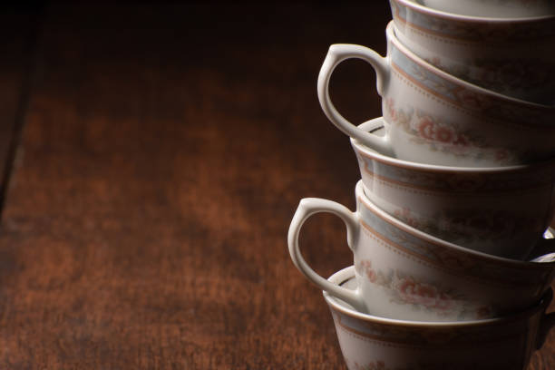istock Porcelain cups, beautiful porcelain cups stacked on rustic wood, dark background, selective focus. 1329710322