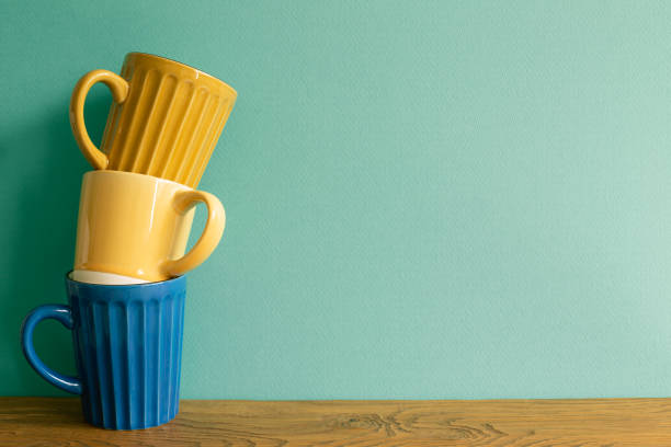 Stack of mug cup on wooden table. mint wall background. copy space