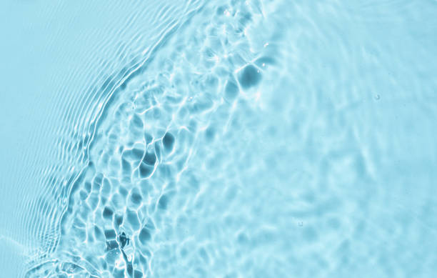 istock Trendy summer nature background. Blue liquid colored clear water surface texture with splashes bubbles. Water waves in sunlight Toner or Emulsion blue colored  background. 1329714312