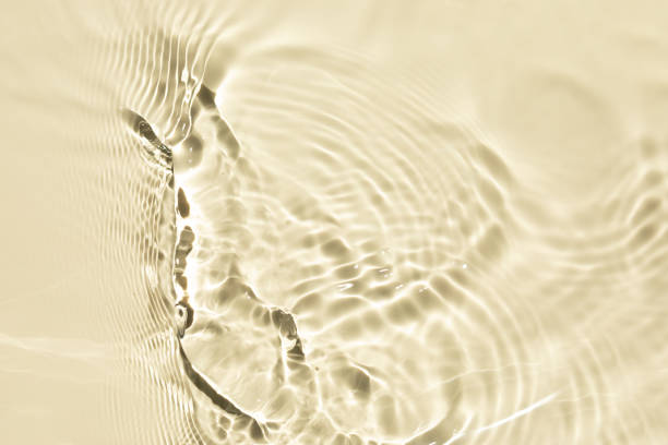 istock Yellow liquid colored clear water surface texture with splashes bubbles. Defocused transparent clear water waves in sunlight. Trendy abstract summer nature background with copy space. 1329714432
