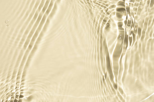 istock Yellow liquid colored clear water surface texture with splashes bubbles. Defocused transparent clear water waves in sunlight. Trendy abstract summer nature background with copy space. 1329715048