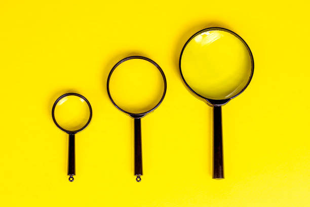 istock Top view of three black magnifying glass on light yellow background 1329715134
